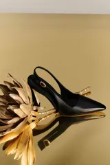 Sandalia de cuero negra con punta fina, tira trasera y taco acampanado. Hecha en Brasil.