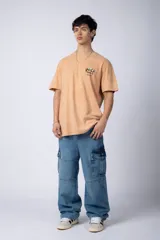 Remera gris con efecto acid wash, corte holgado y estampa frontal con una mano sosteniendo el mundo VCP.