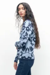 Chaqueta tejida color celeste con estampado floral en tonos oscuros.