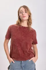 Remera color terracota con cuello redondo y estrellas bordadas alrededor del cuello.