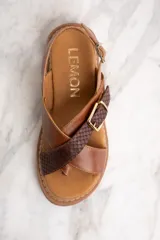 Sandalias marrones con tiras cruzadas de cuero liso y cuero con textura de reptil.