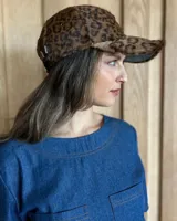 Gorra tipo visera de cuero color celeste, talle único ajustable.