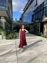 Vestido midi burdeos de breteles finos, con escote en V y volados en el ruedo.