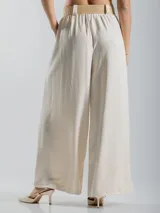 Pantalón italiano tipo wide leg, confeccionado en tela liviana y fresca, color beige. Viene con bolsillos laterales, elástico en la cintura para mayor comodidad y cinto de yute elastizado incluido.