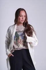 Saco tejido color crema con diseño de ochos y bolsillos frontales.