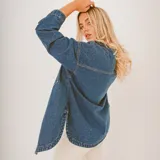 Camisa color crema con botones, de corte holgado y mangas largas.