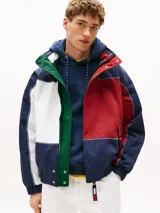 Campera náutica amplia reversible de nailon, con diseño color block en rojo, blanco y azul marino. Tiene capucha fija, cierre de cremallera oculto con botones a presión, puños y bajo elásticos, dos bolsillos ribeteados en la cintura, parche con logo de Tommy Hilfiger en el pecho y logo de Tommy Hilfiger en el cuello, las mangas y la espalda.