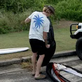 Remera blanca de manga corta con estampado en el pecho de un diseño abstracto en color celeste y texto.