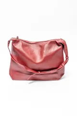Bolso tipo hobo de cuero sintético color rojo oscuro con textura granulada.