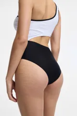 Traje de baño enterizo color verde esmeralda, de un solo hombro, con abertura en la cintura.