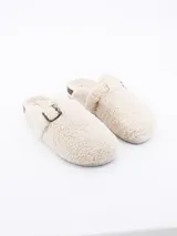 Pantuflas cerradas color crema, forradas en piel sintética con hebilla decorativa.