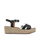 Sandalias de plataforma con suela de yute, tiras cruzadas de cuero negro y plateado, y pulsera al tobillo con hebilla metálica.
