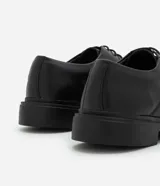 Zapato masculino estilo Oxford, color negro, con punta redonda y cierre de cordones. Posee suela robusta de goma.