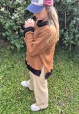 Sweater marrón de punto inglés con cuello alto negro y corte oversize.