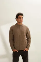 Campera de lana color crema, tejida con cierre delantero, cuello alto y bolsillos delanteros.