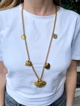 Collar largo dorado con cadena de eslabones y dijes de corazones texturizados.