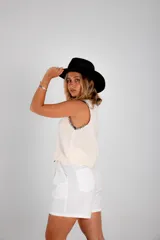 Chaleco tejido celeste con terminaciones en punto festón negro.