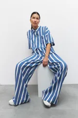 Pantalón largo azul con rayas verticales blancas, de corte amplio, con cintura elastizada y cordón ajustable.