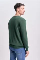 Sweater de punto liso color verde con cuello redondo y mangas largas.