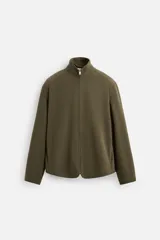 Sobrecamisa verde militar de tejido polar, corte regular fit, cuello alto, cierre frontal con cremallera, manga larga y bolsillos laterales.