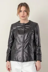 Campera azul de cuero ovino italiano, con cuello redondo, cierre frontal con broches ocultos, bolsillos laterales y detalle de capitoneado en puños y bolsillos.