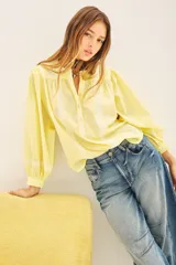 Camisa amarilla de voile con bordados en el frente y las mangas, de corte amplio, con cuello redondo y cierre frontal con botones.