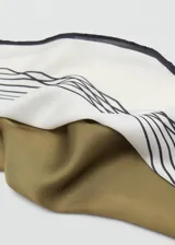 Pañuelo de tejido fluido con acabado satinado, color crema con estampado de líneas negras geométricas y bordes negros.