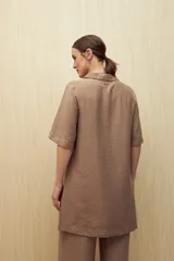 Vestido corto negro de línea relajada con cuello tipo solapa y escote en V profundo, mangas cortas amplias y calce suelto.