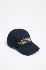 Gorra de béisbol azul marino con bordado floral multicolor en el frente y logo de la marca.