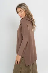 Sweater de punto color beige, con cuello amplio volcado y mangas largas acanaladas.