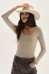 Top de manga larga color beige, confeccionado en tela de lurex, con calce al cuerpo y escote cuadrado.