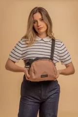 Bandolera pequeña de tela negra, con correa ancha ajustable y cierre superior.