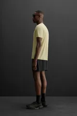Camiseta deportiva color amarillo claro confeccionada en tejido técnico ligero y elástico. Cuenta con cuello redondo, manga corta, costuras termofijadas y estampaciones reflectantes en la espalda.