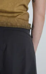 Bermuda negra de corte recto con bolsillos laterales y cinturón con hebilla metálica.