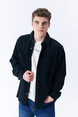 Sobrecamisa verde oscuro de pana con cuello clásico, cierre frontal con botones, dos bolsillos de parche en el pecho y corte recto.