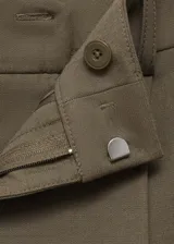 Pantalón color verde oliva, de corte recto y largo, con tiro medio, trabillas y pinzas.