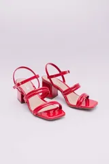 Sandalias rojas de charol con tiras finas y tacón cuadrado.