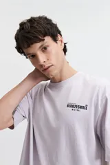 Remera lila de manga corta con corte oversize y estampado pequeño en el pecho.