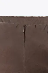 Top marrón sin tirantes confeccionado en tejido fluido, con escote recto, detalle de frunces ajustables con cordones en los laterales y bajo con aberturas laterales.