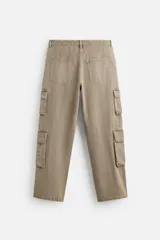 Pantalón cargo de denim color beige, corte relaxed fit, con bolsillos laterales tipo parche con solapa y cierre frontal con botones.