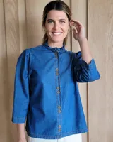 Camisa color crudo, de corte recto, con cuello mao y mangas 3/4 con detalle de puño en contraste.