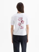 Remera blanca de manga corta con estampado frontal de dos cerezas con forma de labios y el texto "TYPES OF KISSES" en rojo.