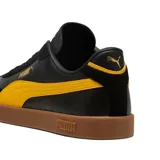 Championes Puma Club LI Era de cuero sintético negro con detalles en amarillo y suela color caramelo.