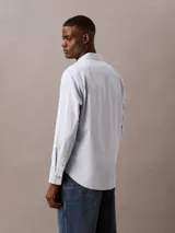 Camisa celeste de algodón Oxford con cuello abotonado, manga larga y logo bordado en el pecho.