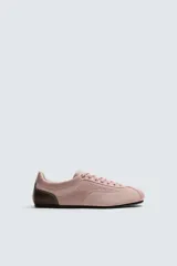 Zapatillas deportivas de piel color rosa con detalles en marrón en la parte trasera. Cierre con cordones al tono.