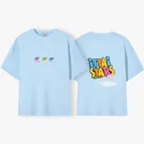 Camiseta celeste de manga corta con cuello redondo y estampado frontal de tres recipientes con cereales. En la parte trasera tiene un estampado grande con el texto "iUTTAi STARS" y un plato con cereales.