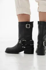 Bota de cuero negra de caña media con hebillas plateadas y cierre lateral.