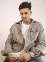 Chaqueta a cuadros con cuello clásico, botones dorados al frente, bolsillos superiores con solapa y bolsillos laterales ribeteados.