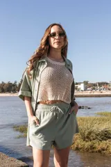 Blusa de tejido de punto calado color crema, sin mangas y corte crop.