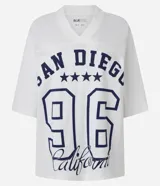 Remera blanca de algodón con cuello en V y corte amplio. Estampado frontal con la inscripción "San Diego", el número 96 y cinco estrellas. Estilo deportivo americano.